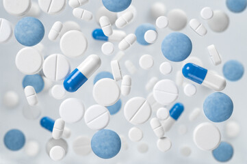 Floating white and blue pills and capsules