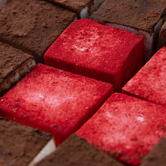 marshmallow, red powder, chocolate coating, diced dessert, close-up. macro