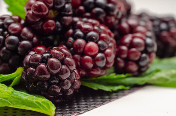Closeup of a set of blackberries with mint, fresh and ripe forest fruits