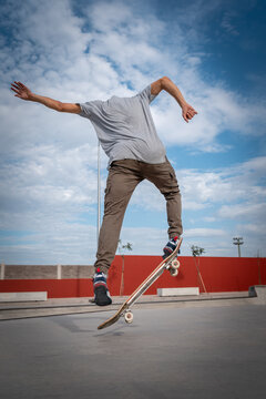 
joven hace un truco llamado kickflip en un parque de patinaje. composici&oacute;n vertical