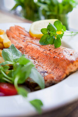 Deep fried wild trout fish served with potato chips fries and fresh salad.