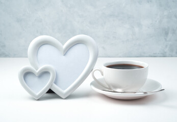 Frame of two hearts and a Cup of coffee on a light background. Side view. The concept of Valentine's day.