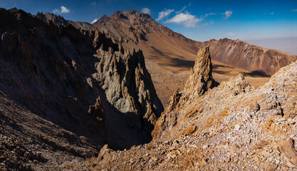 Amazing panoramic landscape of Mount Erciyes. View of the stratovolcano: mountain range, stony slopes, rocky peaks formed by lava flows. Kayseri, Turkey.