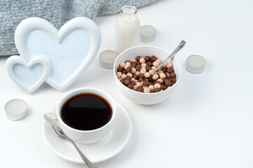 Healthy Breakfast on the background of a frame with hearts and candles on a white background. Coffee and wheat balls. Top view with space to copy. Concept of holiday backgrounds.