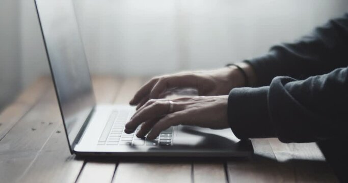 Male freelancer working on laptop at home-office. Close up of hands opening and closing computer with one hand. Businessman writing business letter at work. 4K shot of typing on keyboard