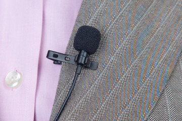 clip-on lavalier microphone is attached to women's clothing close-up. Audio recording of the sound...