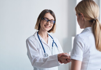 Fototapeta premium woman doctor shakes hands with patient in white t-shirt 
