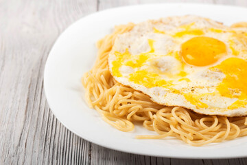 scrambled eggs with pasta on a white plate