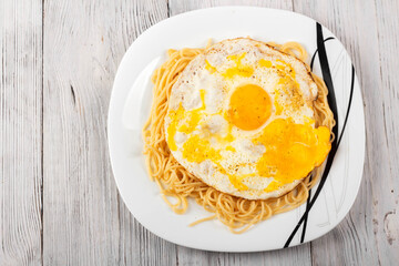 scrambled eggs with pasta on a white plate