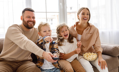 Happy family watching tv together.
