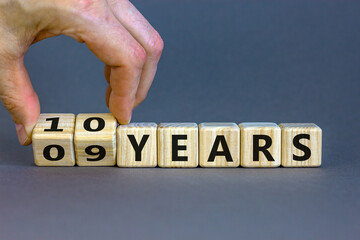 Male hand turns cubes and changes the expression '09 years' to '10 years' or vice versa. Beautiful...