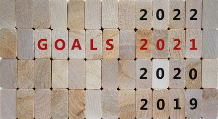 Business concept of planning 2021. Wooden blocks with the inscription 'Goals 2021'. 2019, 2020, 2022 numbers. Beautiful wooden background, copy space.