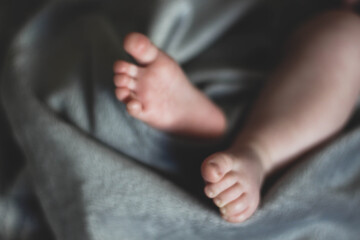small sweet baby feet on the bedspread