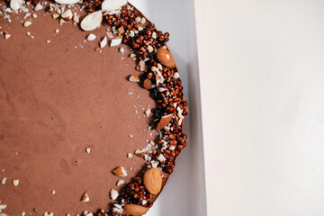 Homemade chocolate cake with nuts. Food delivery. Homemade baking. Top view. Delicious tart with chocolate and nuts in a cardboard box. Close-up.
