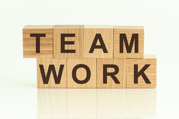 Team Work - text on wooden cubes on a white gradient background.