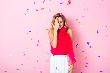 elegant happy woman in crown under confetti on pink background