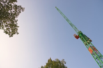 Abstract looking up at the underside of a huge tower crane and trees