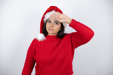 Young beautiful woman wearing a Santa hat over white background Touching forehead for illness and fever, flu and cold, virus sick