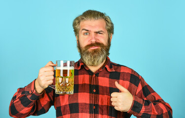lager beer. relaxed handsome man sipping delicious beer. enjoying glass at pub. anticipating fresh...