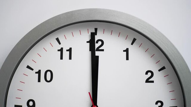 Close up of a ticking clock on white background, pointing midnight, time lapse