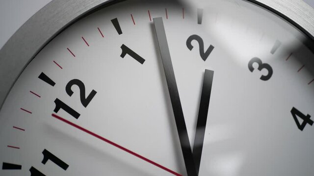Close up of a ticking clock on white background, window reflection