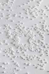 Christmas star imprint in the snow. New Year's decor. Christmas or winter composition. Snowflakes and snowball on a white background.Christmas, winter, new year concept. Flat lay, top view.