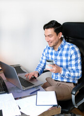 Man in casual outfit working from home with a laptop in the living room