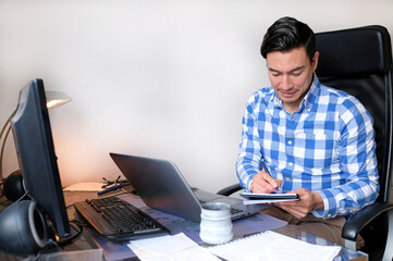 Man in casual outfit working from home with a laptop in the living room