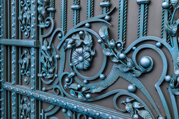 Beautiful forged elements of a metal gate in blue tones