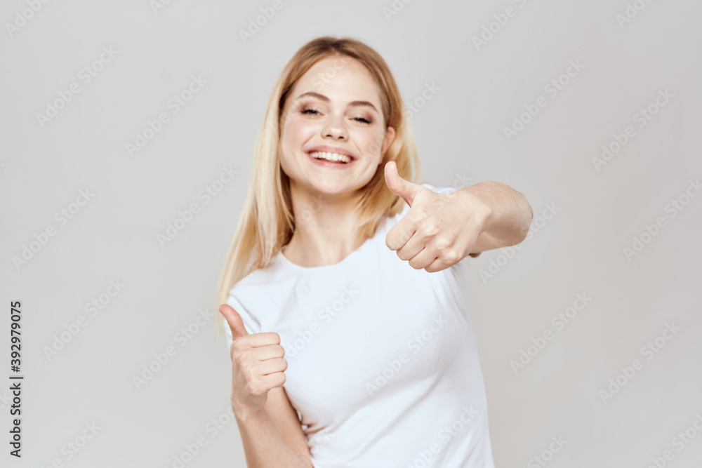 Wall mural Cute blonde white t-shirt gesture with hands lifestyle light background