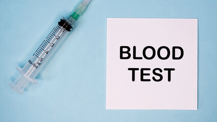 'Blood test' message on sticker with syringe near. Mecal concept of flu prevention.