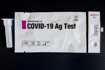 A rapid antigen test for Covid-19 coronavirus contagion control and its packaging with special diluent on a black background