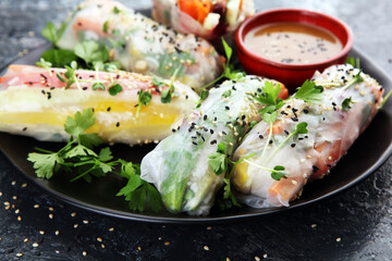 Fried chinese spring rolls with sweet chili sauce on rustic background