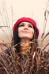 A beautiful girl with a red beret and dried autumn herbs