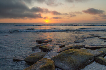 A sunset from a rocky shore along the coast of California.