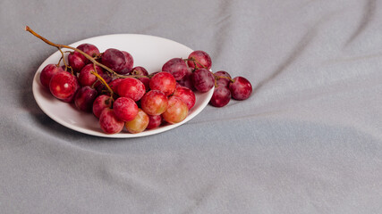 Still life of a bunch of grapes on a grey tablecloth