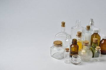 Empty glass bottles on a light background. Various vessels for cosmetics and perfumes.