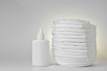 Baby diapers and diaper rash powder on a white background. There is space for text.