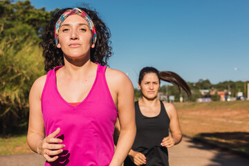 Brunette sportswomen exercising outdoors - Young fitness women training for outdoor marathon