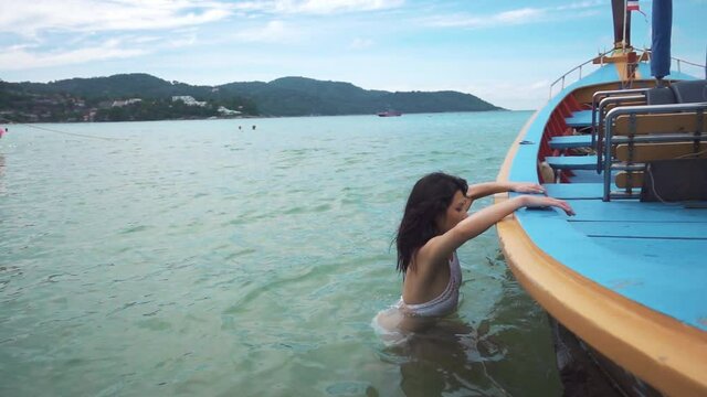 Woman jump into long tail boat