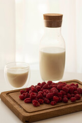 Healthy breakfast is fresh organic raspberries, strawberries with milk jug on an old wooden background. Rustic style.
