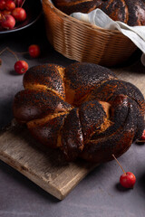 Homemade poppy seeds cake and spruce branches on rustic board, dessert and decoration for Christmas, rolled up traditional polish poppy pie
