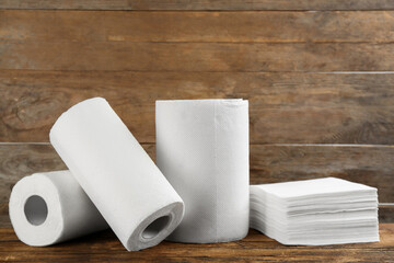 Clean napkins and rolls of paper towels on wooden table