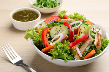 Delicious fresh chicken salad served on wooden table, closeup