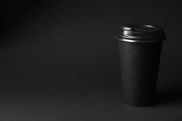 Takeaway paper coffee cup on dark background, space for text. Black Friday concept