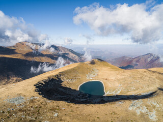 Aerial panoramic shot of a natural lake on a mountain