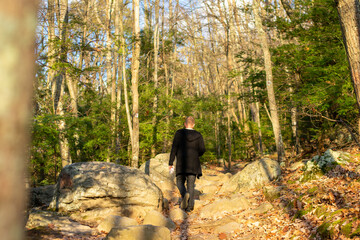 Fototapeta premium A Man Wearing All Black Climbing Up a Mountain Path