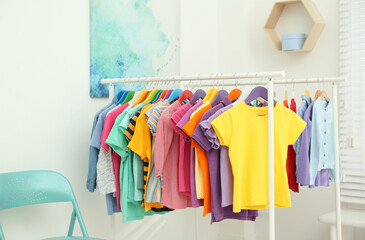 Different child's clothes hanging on racks in room