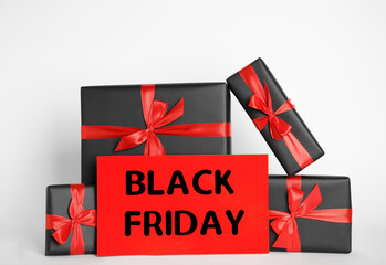 Many gift boxes and sheet of paper with words Black Friday on white background