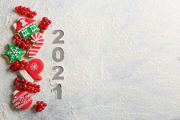 Flat lay composition with homemade Christmas cookies and number 2021 made of flour on grey table....